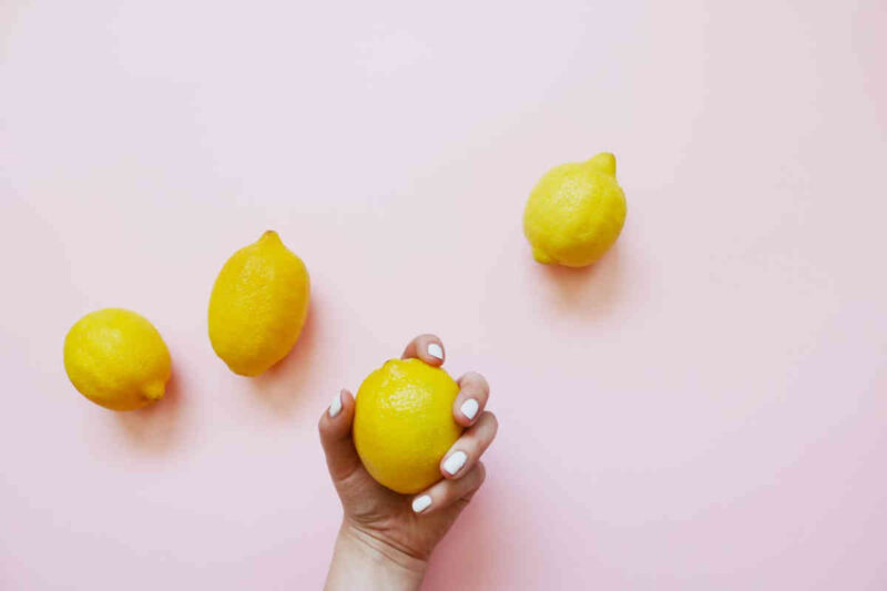 Tre limoni su ripiano e uno in mano