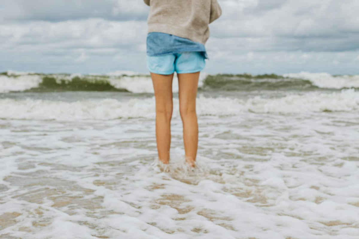 Ragazza con i piedi immersi nell'acqua di mare