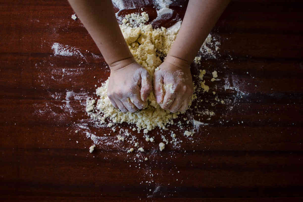 Mani che lavorano la pasta frolla