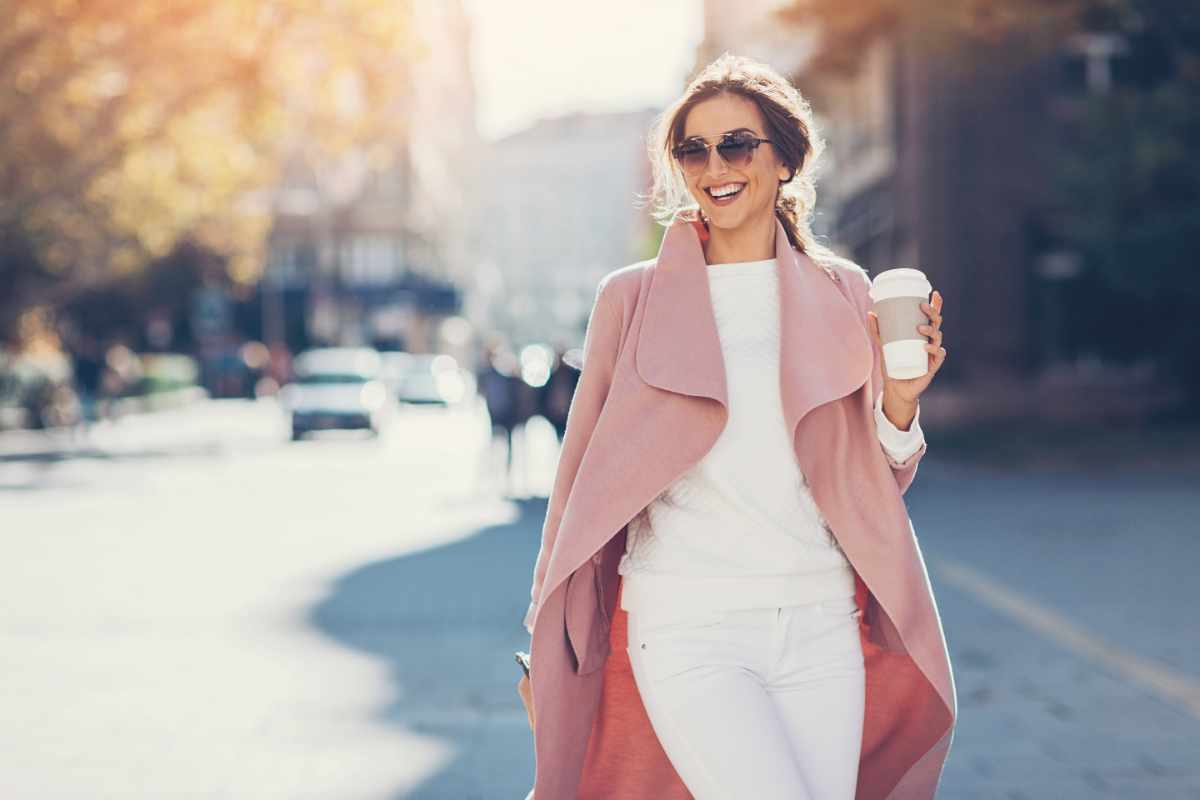 donna con completo bianco e cappotto rosa