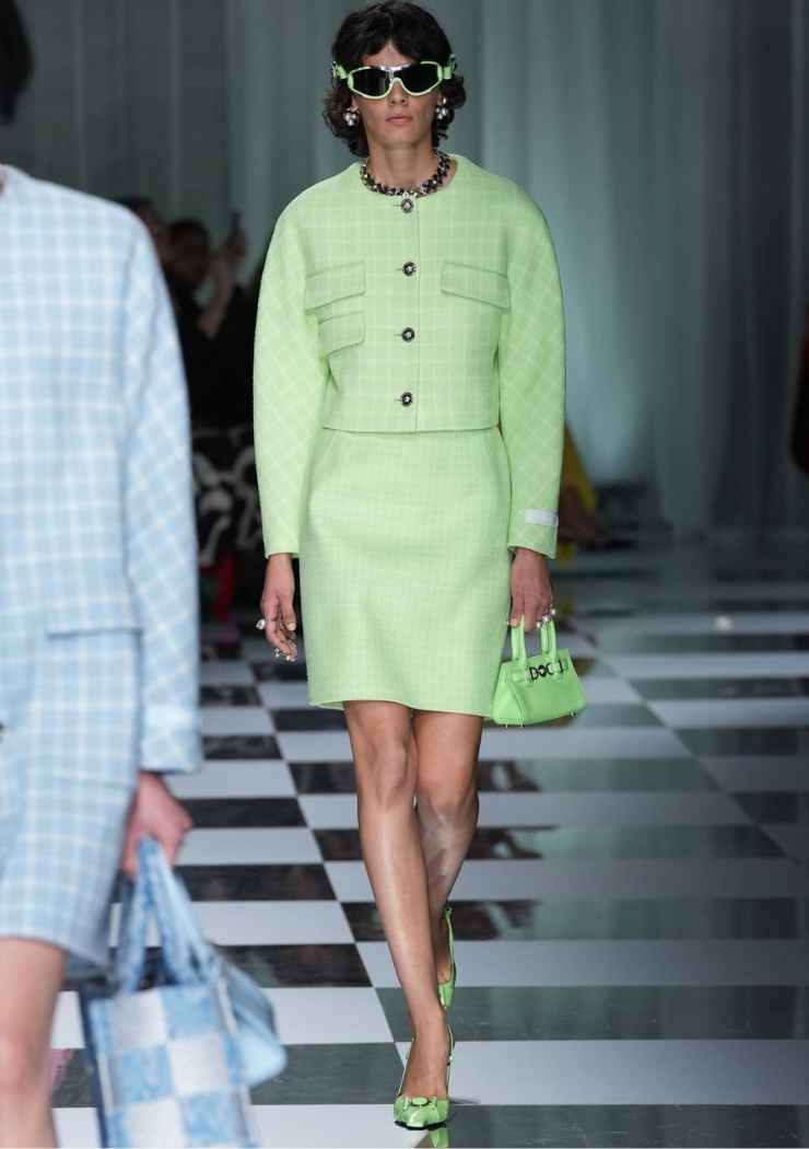 Modella con tailleur verde e borsa dello stesso colore