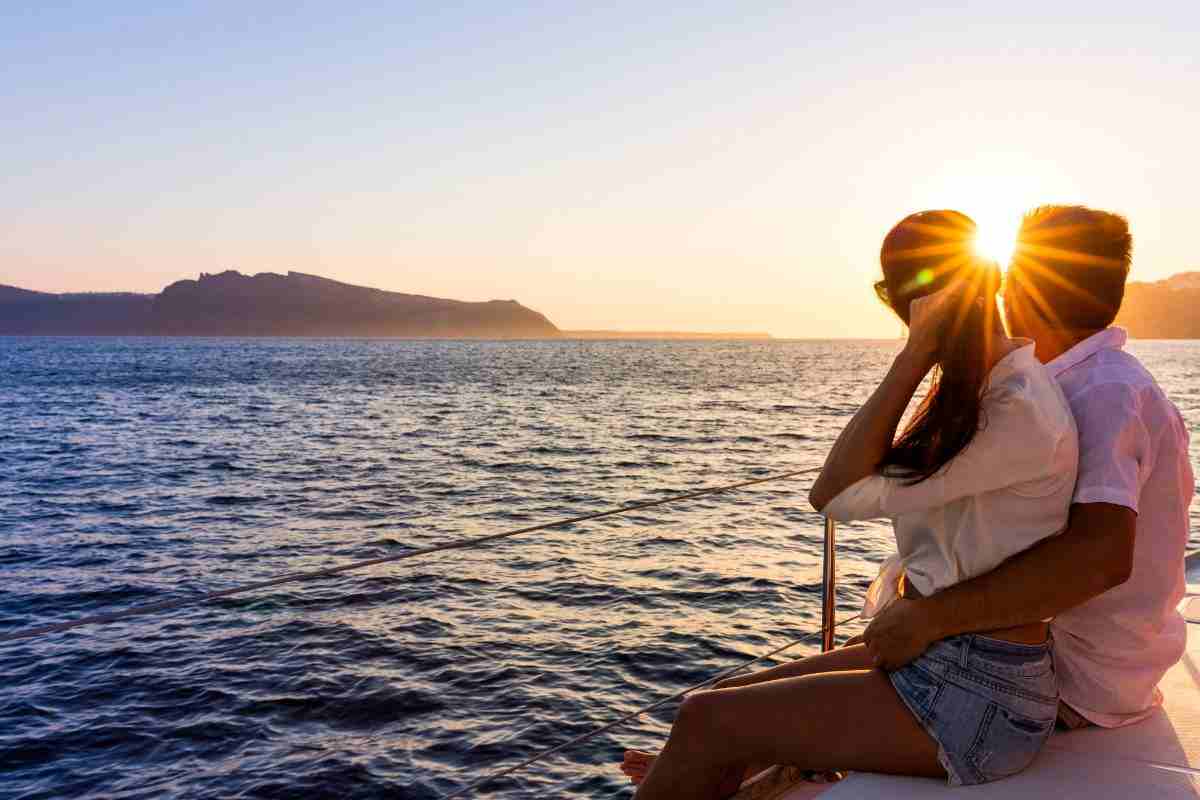 Coppia seduta in barca che guarda tramonto
