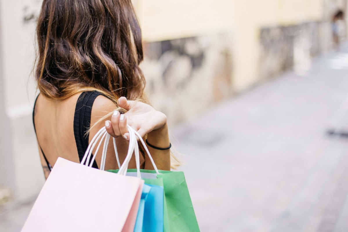 Ragazza che fa shopping per borse bianche