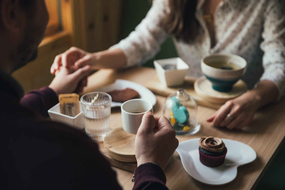 coppia che si tiene per mano in un ristorante