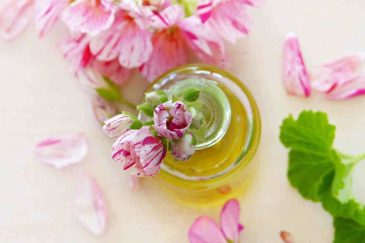 Olio con petali di rosa in una ampolla di vetro