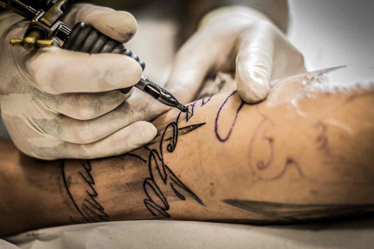 Tatuatore che tatua