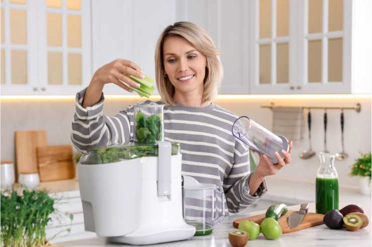 donna che prepara centrifuga di verdure e frutta