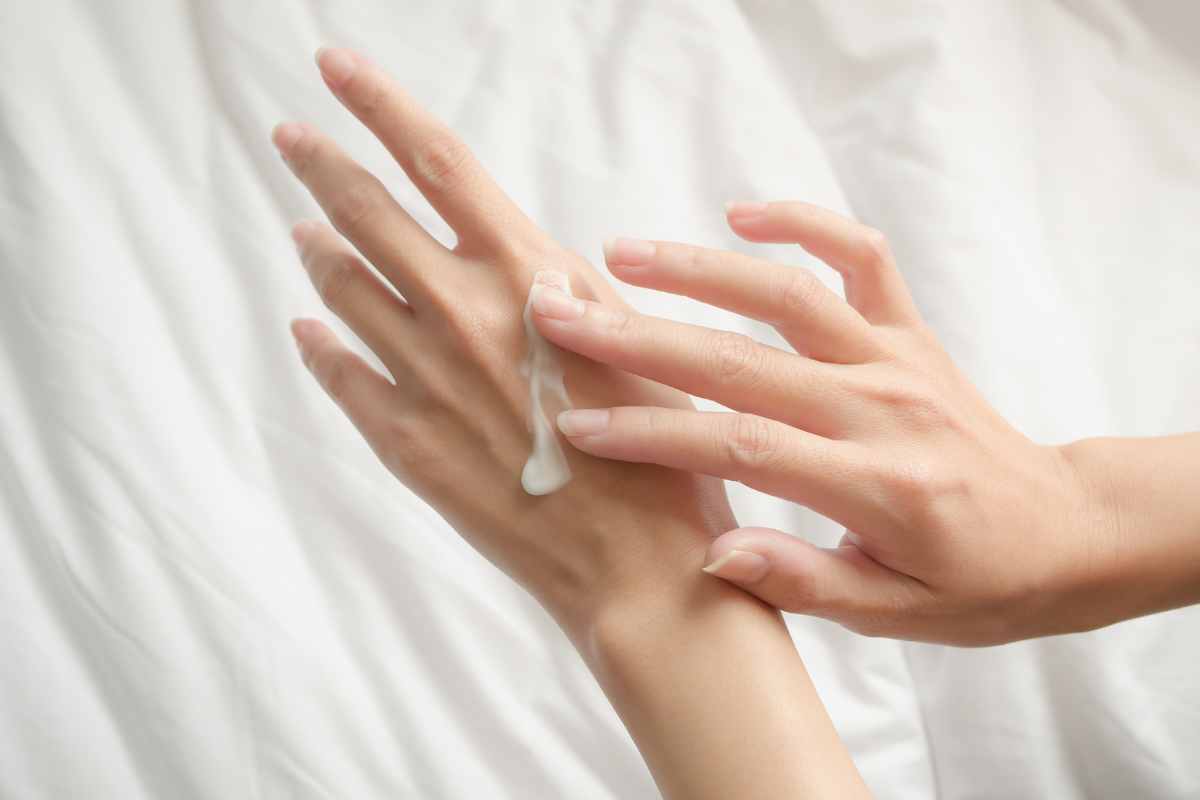 primo piano mani donna con crema