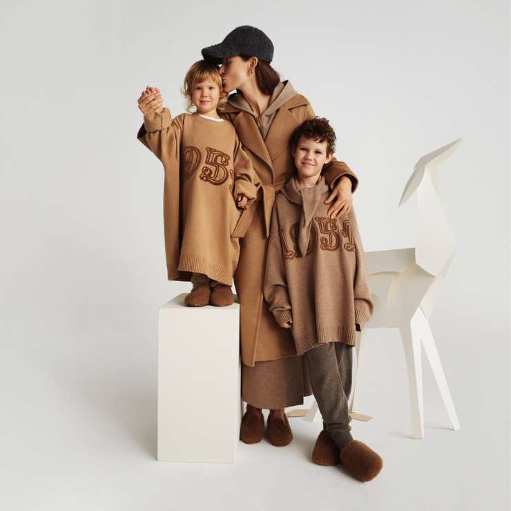 modella con cappotto cammello e due bambini con maglioni oversize