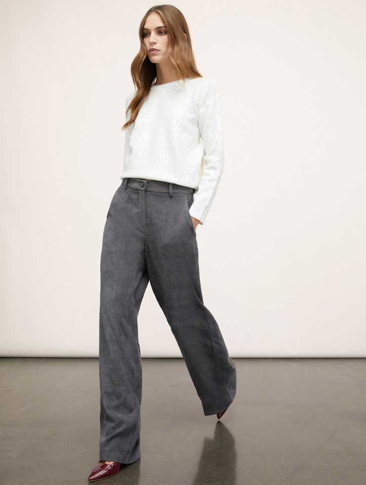 modella pantaloni palazzo grigi e maglia bianca