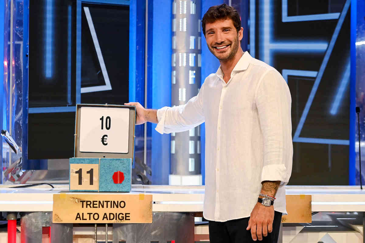 Il presentatore di Affari tuoi Stefano De Martino mentre apre una scatola durante la trasmissione